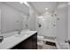 Contemporary bathroom features a glass shower, white tile, and a dark vanity with a light countertop at 17909 Golden Meadow Ct, Davidson, NC 28036