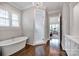 Spa-like bathroom with soaking tub, glass shower, and hardwood floors at 17909 Golden Meadow Ct, Davidson, NC 28036