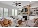 Cozy living room with stone fireplace, built-in shelves, large windows, and comfortable seating at 17909 Golden Meadow Ct, Davidson, NC 28036
