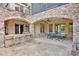 Covered patio with stone bar, seating, and ping pong table for entertaining in an elegant outdoor space at 17909 Golden Meadow Ct, Davidson, NC 28036