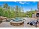 Beautiful backyard pool with a stone spa and rock waterfall feature surrounded by lush landscaping at 17909 Golden Meadow Ct, Davidson, NC 28036