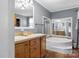 Bright bathroom featuring double sinks, tile floors and a large soaking tub at 1821 Hopewell Church Rd, Hiddenite, NC 28636