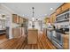 Spacious kitchen with wood cabinets, stainless appliances, center island with seating, and wood flooring at 1821 Hopewell Church Rd, Hiddenite, NC 28636