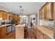 Well-lit kitchen featuring wood cabinets, tile countertops, stainless steel appliances, and wood flooring at 1821 Hopewell Church Rd, Hiddenite, NC 28636