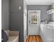 Functional laundry room with gray walls, wood floors, washer, dryer, and utility sink with outside exit at 1821 Hopewell Church Rd, Hiddenite, NC 28636