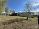 Exterior of home with screened porch and large backyard with mature trees on a sunny day at 1869 Wooten St, Catawba, NC 28673