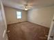 Bright bedroom with neutral carpet, a ceiling fan, and a large window for natural light at 1869 Wooten St, Catawba, NC 28673