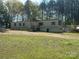 Exterior view of a single-wide home with green grass and tall trees at 1869 Wooten St, Catawba, NC 28673