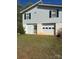 Two-story home featuring a garage door and a small door on the ground level and black shuttered windows at 1869 Wooten St, Catawba, NC 28673