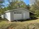 External garage with white siding and a garage door with windows and a covered area on the side at 1869 Wooten St, Catawba, NC 28673
