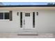 Close-up of a bright white front door, flanked by windows and stylish sconces at 1904 27Th Avenue Ne Dr, Hickory, NC 28601