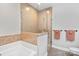 Bathroom with large white tub, tile flooring and tile and glass enclosed walk-in shower at 20217 Middletown Rd, Cornelius, NC 28031