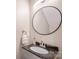 Bathroom vanity with granite countertops, stainless steel faucet, and a large round mirror at 20217 Middletown Rd, Cornelius, NC 28031