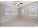 Staged bedroom showcasing multiple windows, neutral carpet, and a ceiling fan at 20217 Middletown Rd, Cornelius, NC 28031