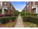 A picturesque pathway lined with lush greenery and manicured hedges between two brick homes at 20217 Middletown Rd, Cornelius, NC 28031