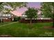 Beautiful landscaped backyard with a brick fence surrounding lush greenery. *Virtually Staged* at 20217 Middletown Rd, Cornelius, NC 28031