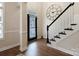 Inviting foyer featuring hardwood floors, a staircase, and a striking oversized decorative wall clock at 20217 Middletown Rd, Cornelius, NC 28031