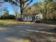 Charming single-story home with a covered porch, mature trees, and gravel driveway at 2122 Hope Dr, Rock Hill, SC 29730