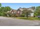 Exterior view of a brick and siding condo building with well-maintained landscaping and mature trees at 2515 Carya Pond Ln, Charlotte, NC 28212