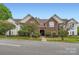 Brick and siding condo with manicured landscaping, mature trees, and covered balconys enhance curb appeal at 2515 Carya Pond Ln, Charlotte, NC 28212