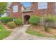 Charming brick condo building featuring an arched entryway and well-manicured landscaping at 2515 Carya Pond Ln, Charlotte, NC 28212