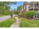 Exterior view of a condo building showcasing a curved walkway, green lawns, and mature trees at 2515 Carya Pond Ln, Charlotte, NC 28212