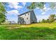 Backyard showcasing the home's exterior, spacious lawn, and scenic landscape with blue skies at 2668 Polo Ln, Maiden, NC 28650