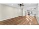 Open-concept living room featuring modern wood floors, a ceiling fan, and easy access to a bright, modern kitchen at 2668 Polo Ln, Maiden, NC 28650