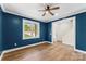 Stylish living room with blue accent wall, hardwood floors and a ceiling fan at 2668 Polo Ln, Maiden, NC 28650
