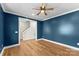 Stylish living room with blue accent wall, hardwood floors and a ceiling fan at 2668 Polo Ln, Maiden, NC 28650