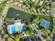 Aerial view showcasing community amenities, including a pool, tennis courts, and a scenic pond at 2684 Sunberry Nw Ln, Concord, NC 28027