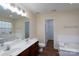 Large primary bathroom with dual sinks, walk-in closet, tub, and separate shower at 2684 Sunberry Nw Ln, Concord, NC 28027
