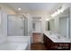 Primary bathroom featuring dual sink vanity, separate shower, large soaking tub, and updated fixtures at 2684 Sunberry Nw Ln, Concord, NC 28027