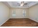 Open primary bedroom with hardwood floors, two windows, and a ceiling fan at 2684 Sunberry Nw Ln, Concord, NC 28027