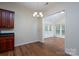 Dining area with hardwood floors, elegant chandelier, and open access to the adjacent, well-lit sunroom at 2684 Sunberry Nw Ln, Concord, NC 28027