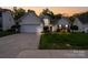 Charming single-Gathering home at dusk with a well-manicured lawn and two-car garage at 2684 Sunberry Nw Ln, Concord, NC 28027