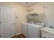 Functional laundry room featuring a washer, dryer, utility sink, and white wire rack shelving above at 2684 Sunberry Nw Ln, Concord, NC 28027