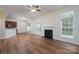 Bright living room featuring hardwood floors, a fireplace, ceiling fan, and natural light from large windows at 2684 Sunberry Nw Ln, Concord, NC 28027