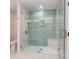 Modern bathroom featuring a glass shower with green tiling, gold hardware, and shower bench at 2717 Springway Dr, Charlotte, NC 28205