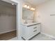 Bathroom with double sink vanity, framed mirror, and large walk-in closet visible through doorway at 2717 Springway Dr, Charlotte, NC 28205