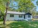 Charming white brick home with a black roof and a beautifully landscaped front yard at 2717 Springway Dr, Charlotte, NC 28205