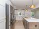 Bright kitchen with stainless steel refrigerator and central island, with gold hardware and light fixtures at 2717 Springway Dr, Charlotte, NC 28205