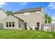 Home's backyard features a manicured lawn and a cozy patio seating area at 3039 Keswick Ter, Indian Land, SC 29707