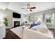 Living room with a fireplace, dark hardwood floors, a ceiling fan, and bright white couches at 3039 Keswick Ter, Indian Land, SC 29707