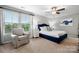 Well-lit main bedroom featuring a queen size bed, ceiling fan, chair and large windows at 3039 Keswick Ter, Indian Land, SC 29707