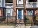Charming townhouse entrance featuring a vibrant blue door, wrought iron fence, and brick accents at 3064 Selwyn Ave, Charlotte, NC 28209