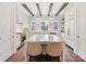 Bright, all-white kitchen with hardwood floors, marble island, modern appliances, and stylish lighting at 3064 Selwyn Ave, Charlotte, NC 28209