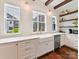 Bright kitchen featuring white cabinets, hardwood floors, and a farmhouse sink with brass fixtures at 3064 Selwyn Ave, Charlotte, NC 28209
