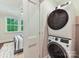 Efficient laundry area with stackable washer and dryer, adjacent to a bedroom featuring a view of verdant trees at 3064 Selwyn Ave, Charlotte, NC 28209