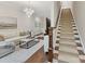 A staircase connects the living area, featuring a white sofa and modern light fixture at 3064 Selwyn Ave, Charlotte, NC 28209